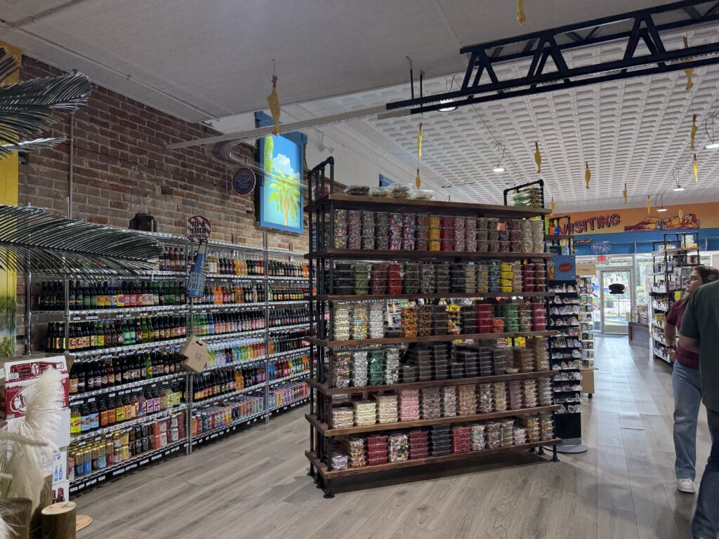 Rows of bottled sodas and colorful candy at Grandpa Joe's Candy Shop