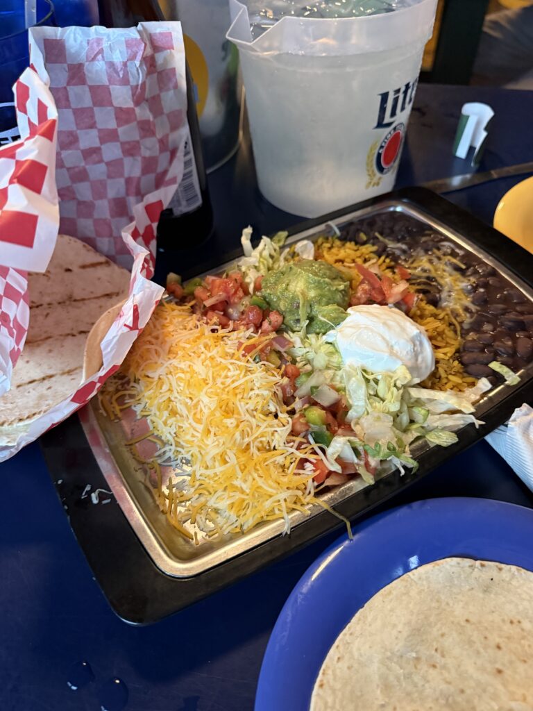 Mexican-style platter with rice, beans, lettuce, tomatoes, guacamole and tortillas