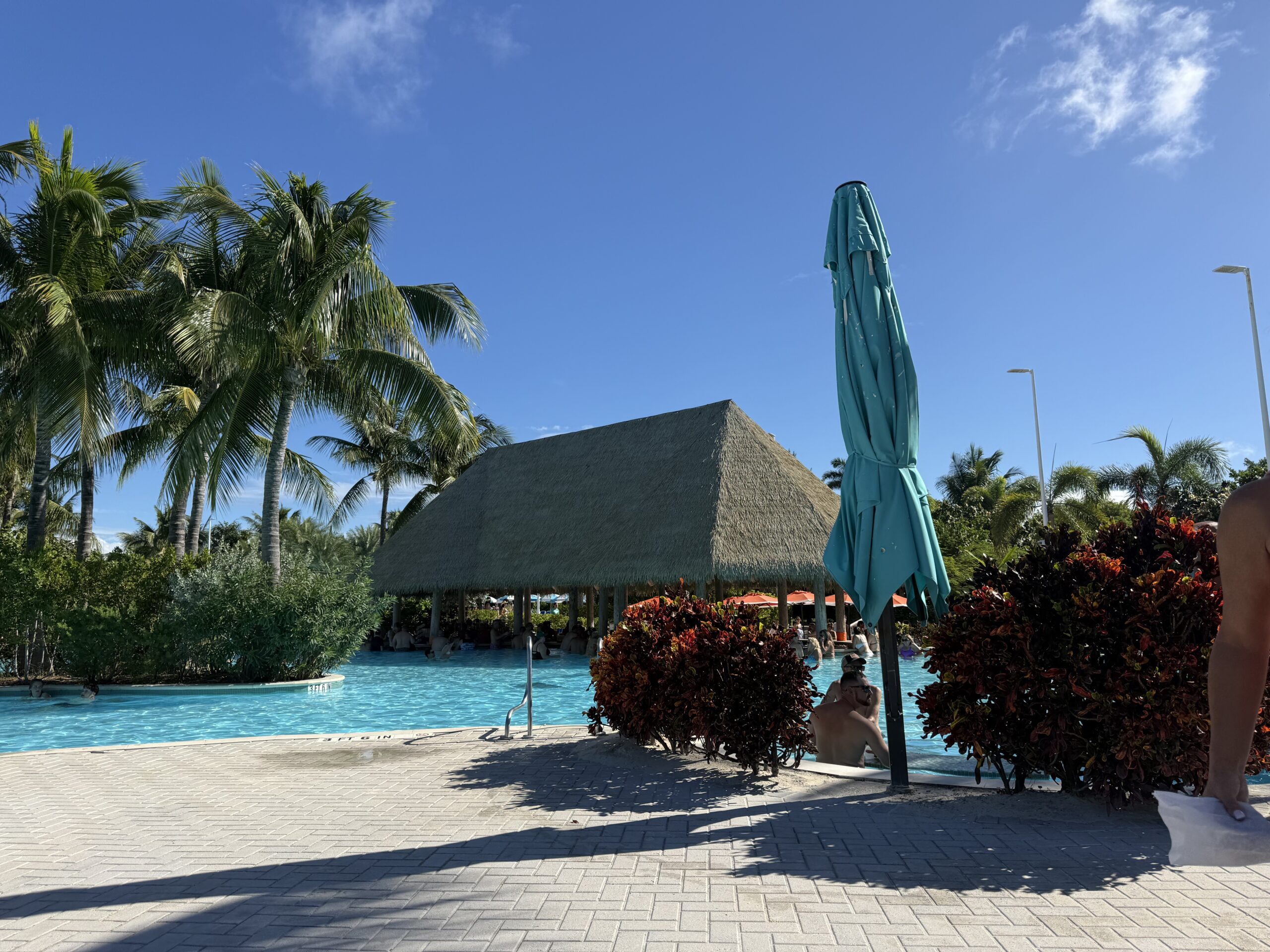 Swim-up bar beneath a thatched roof beside a turquoise pool at Perfect Day at CocoCay