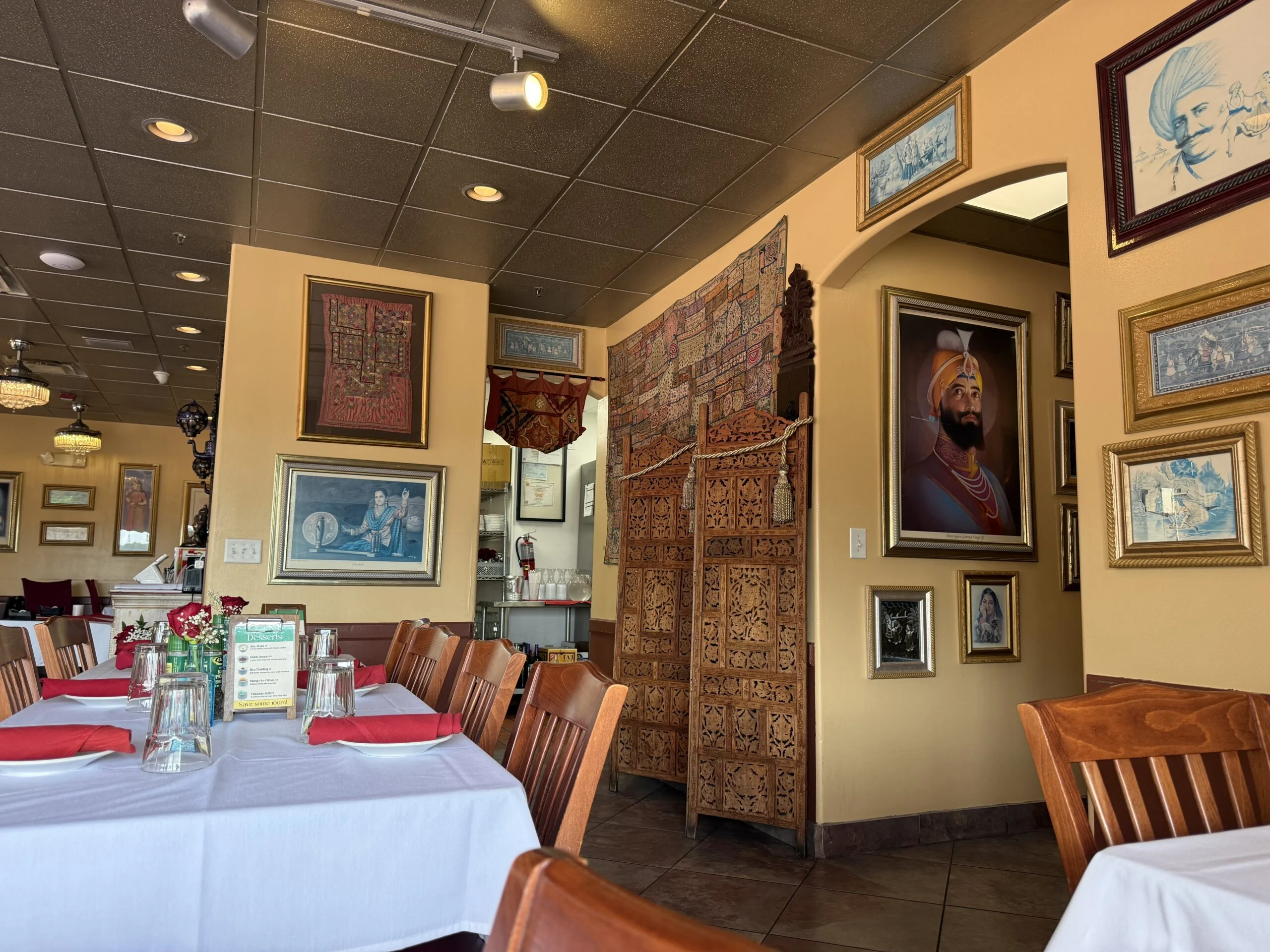 Guru’s dining room with white tablecloths, red napkins and wooden chairs