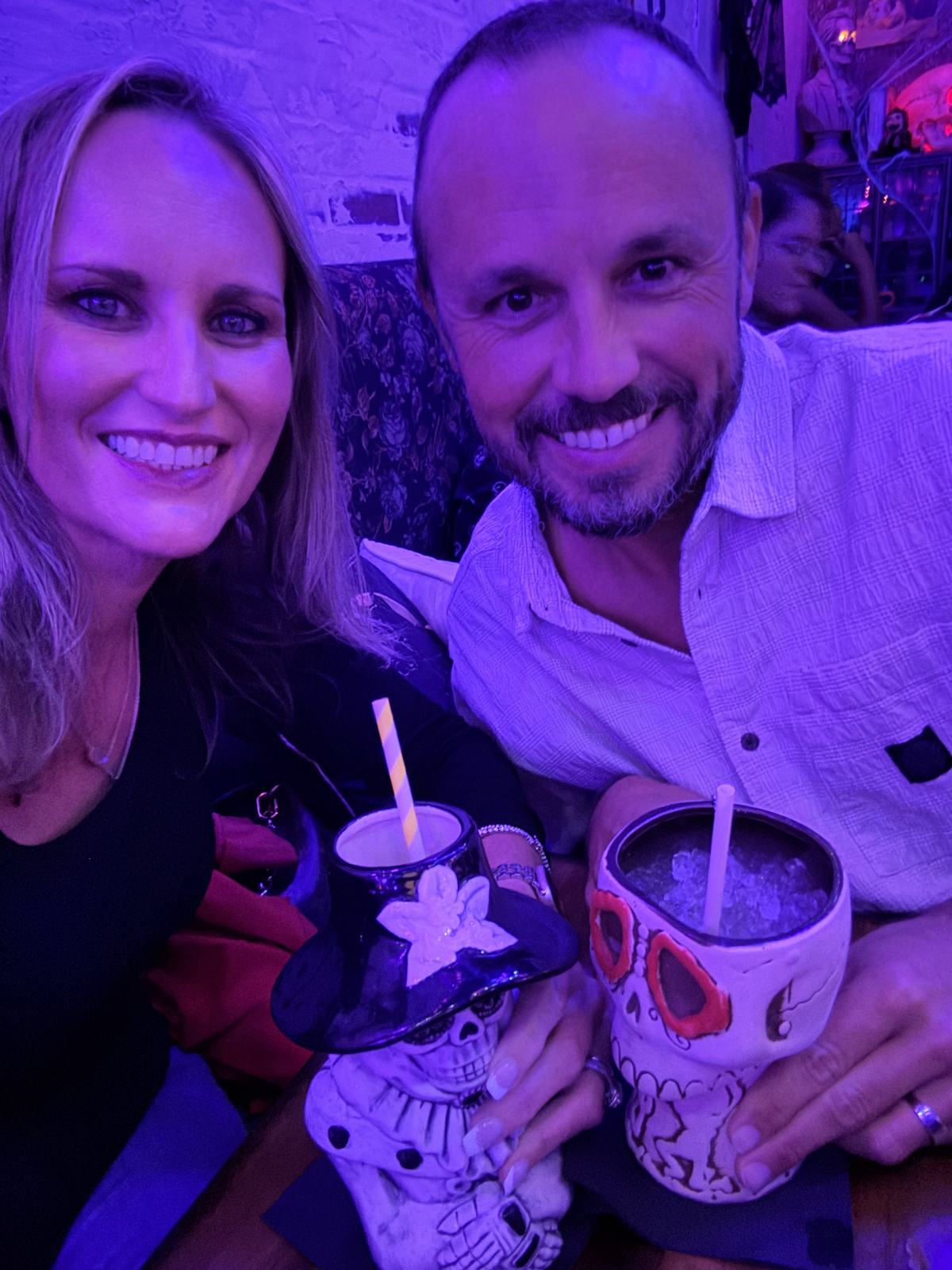 Jason and Danielle posing with skull-themed cocktail cups during their BTW Spookeasy visit.