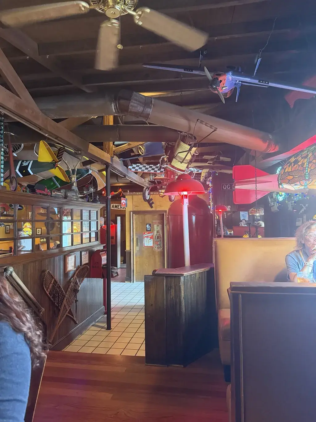 Upstairs seating at Jeremiah’s in Mount Dora, with wooden beams and model airplanes overhead.