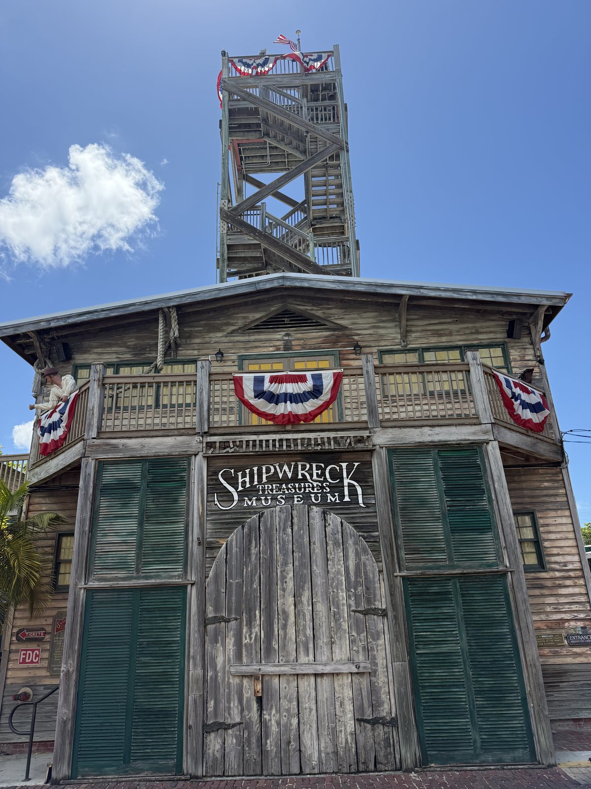 Key West Shipwreck Museum wooden entrance and tall observation tower.