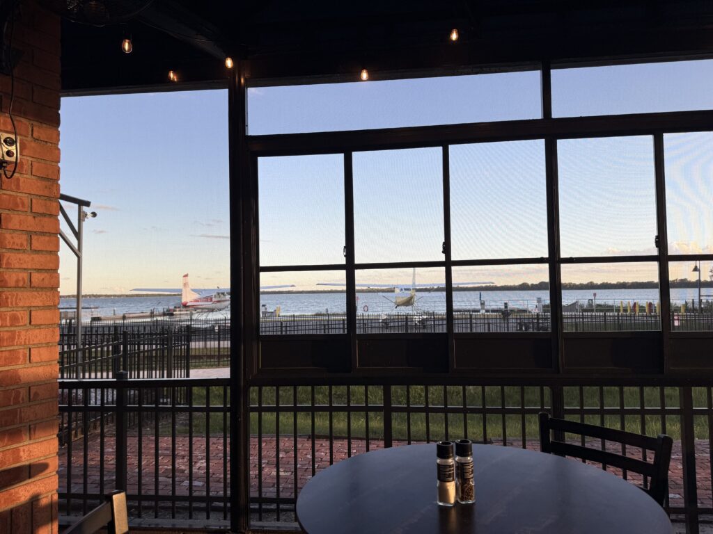 View of seaplanes on the Lake Dora waterfront through the covered patio at Puddle Jumpers in Tavares