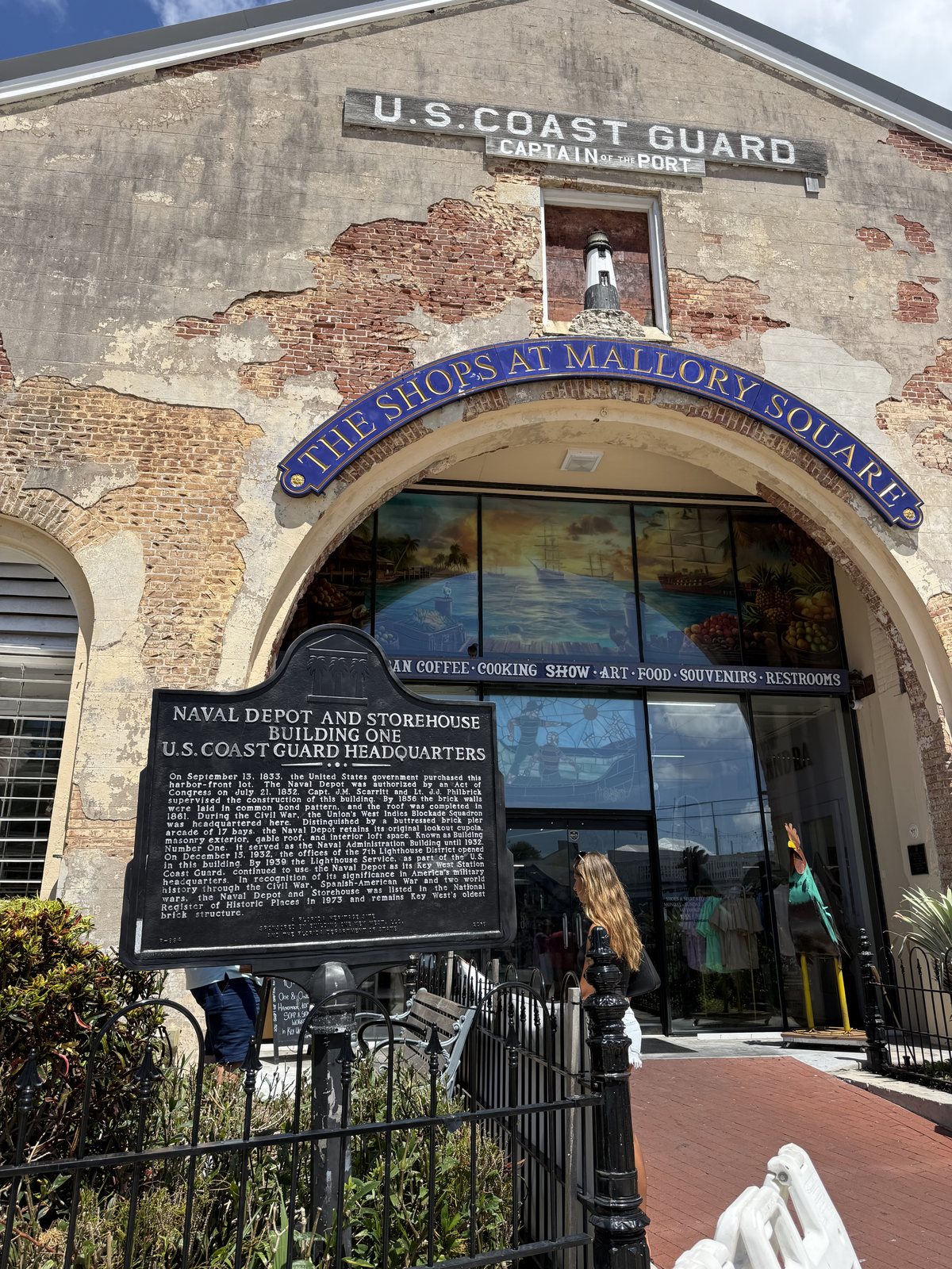 Historic U.S. Coast Guard building with the Shops at Mallory Square entrance sign.