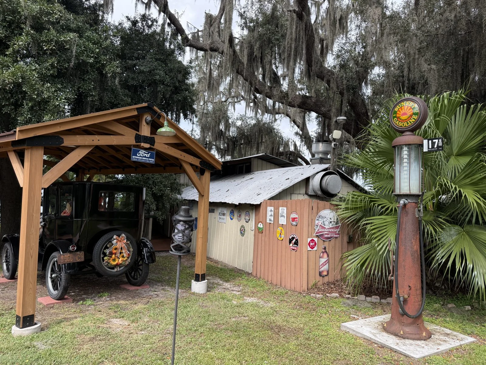 Wooden entrance to Tiki Bar & Grill in Minneola beneath oak trees draped with Spanish moss.