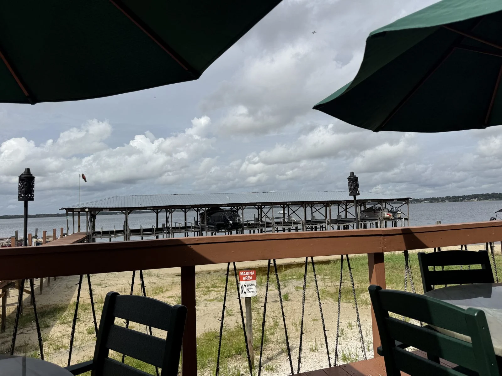 View across Lake Minneola toward a covered dock from the tiki bar’s waterfront deck.