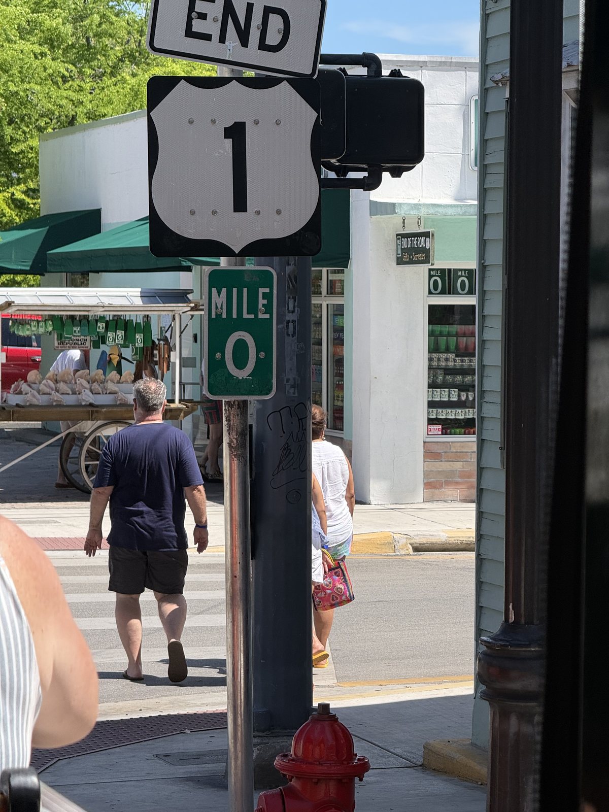 U.S. Route 1 End sign and green Mile 0 marker photographed from the trolley in Key West.